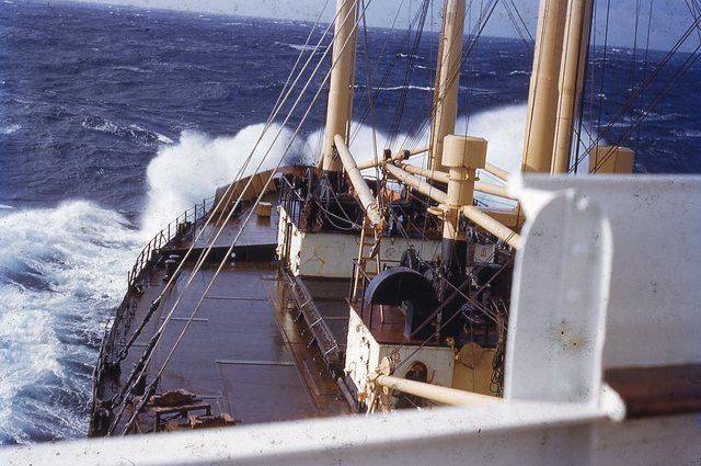 From a ship in 1950 but the set-up is the same. Note the steel bands on the hatch. The canvas is probably dark green but looks darker because it's wet.
